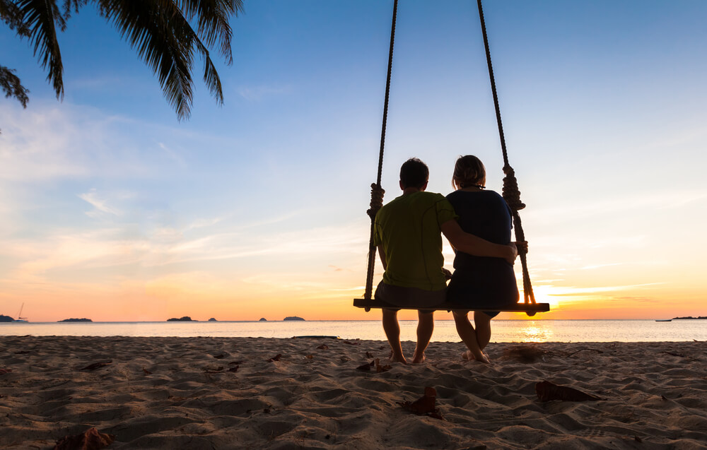 Two people on a swing watching the sunset, one of the many things to do on Paradise Island.