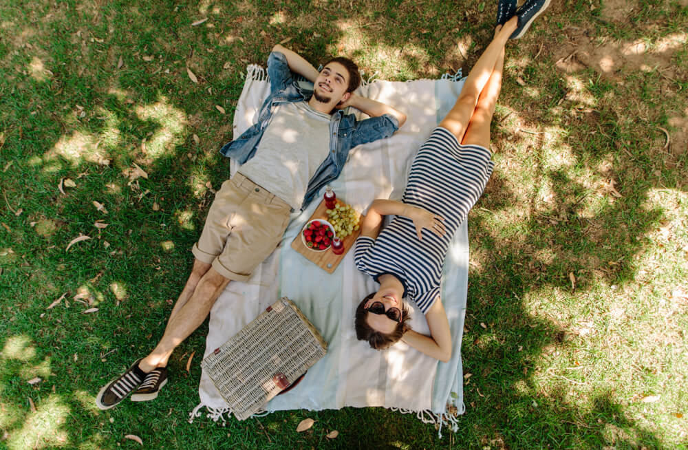 A couple enjoying a picnic date at a Nassau park.